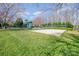 Community playground and sand volleyball court surrounded by green grass under a bright blue sky at 10111 Grimsby Ct, Huntersville, NC 28078