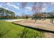 Community playground with slide, swings, and sand volleyball court under a bright blue sky at 10111 Grimsby Ct, Huntersville, NC 28078