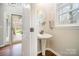 Cozy powder room with pedestal sink and natural light at 10111 Grimsby Ct, Huntersville, NC 28078