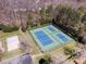 Aerial view of tennis and volleyball courts surrounded by trees and a parking area at 10111 Grimsby Ct, Huntersville, NC 28078