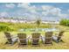 Four adirondack chairs overlooking a pond and community homes at 127 Doncaster Dr, Mooresville, NC 28115