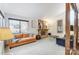 Living room with a stone fireplace, large windows, and a comfortable orange couch at 1419 Jules Ct, Charlotte, NC 28226