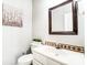 Small bathroom with toilet, sink, and decorative mirror at 15011 Edindale Dr, Charlotte, NC 28277