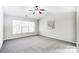 Bright bedroom with gray carpet, ceiling fan, and large window at 15011 Edindale Dr, Charlotte, NC 28277