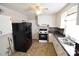 Galley kitchen with white cabinets and black appliances at 1750 Oak Valley Dr, Gastonia, NC 28054