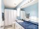 Clean bathroom with blue walls, white vanity, and shower/tub combo at 1825 Bloomsbury Dr, Rock Hill, SC 29730