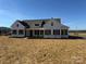 White farmhouse exterior with dark trim, landscaping, and expansive yard at 2906 Lathan Rd, Monroe, NC 28112