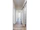 Hallway with wood floors leading to rooms with white doors and sliding barn door at 2906 Lathan Rd, Monroe, NC 28112