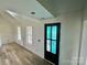 Bright hallway with light walls, wood-look floors, and a black door at 2906 Lathan Rd, Monroe, NC 28112