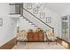 Spacious foyer with staircase, hardwood floors, modern lighting, and decorative rug at 373 Hillside Ave, Charlotte, NC 28209