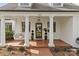 Inviting front porch with brick flooring, white columns, and hanging porch swing at 373 Hillside Ave, Charlotte, NC 28209