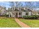 Charming white home with well-kept lawn, brick pathway and covered front porch with swing at 373 Hillside Ave, Charlotte, NC 28209