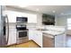 Well-lit kitchen featuring stainless steel appliances, granite counters, white cabinets, and open view to living area at 3988 Crestview Dr, Rock Hill, SC 29732