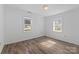 Bright bedroom with wood-look floors and natural light streaming through two windows at 413 Shinnville Rd, Mooresville, NC 28115