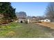 Exterior home view with a lawn, landscaping, and tall trees at 413 Shinnville Rd, Mooresville, NC 28115