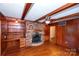 Gathering room with brick fireplace, wood paneling and hardwood floors at 4308 Glenfall Ave, Charlotte, NC 28210