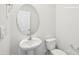 This bathroom features a pedestal sink, toilet and a round mirror at 4618 Harris Elliot Rd, Lincolnton, NC 28092