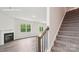 Entryway with wood and metal banister with stairs leading upstairs and a fireplace in the living room at 4618 Harris Elliot Rd, Lincolnton, NC 28092