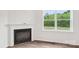 Bright living room with a classic fireplace and large window showcasing a green backyard at 4618 Harris Elliot Rd, Lincolnton, NC 28092