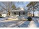 Charming white cottage with a covered porch, freshly landscaped yard, and snowy front lawn at 520 Waddell Dr, Albemarle, NC 28001