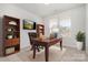 Home office with a wooden desk and shelves. Sunny windows and a mounted TV at 545 Shallowford Dr, Rock Hill, SC 29732