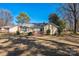 Expansive backyard featuring a deck, mature trees, lawn and back view of home at 5701 Glenshire Ct, Charlotte, NC 28269