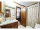 Modest bathroom featuring a vanity with sink, mirror and floral shower curtain at 5701 Glenshire Ct, Charlotte, NC 28269