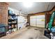 Spacious garage featuring a garage door, brick wall, storage shelves and concrete floor at 5701 Glenshire Ct, Charlotte, NC 28269