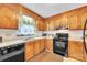 Functional kitchen with wooden cabinets, black appliances, and lots of counter space at 5701 Glenshire Ct, Charlotte, NC 28269