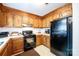 Functional kitchen with wooden cabinets, black appliances and white countertops at 5701 Glenshire Ct, Charlotte, NC 28269