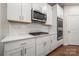 White kitchen with stainless steel appliances and herringbone backsplash at 717 Windage Way, Pineville, NC 28134