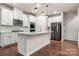 Modern kitchen with white cabinets, stainless steel appliances, and a large island at 717 Windage Way, Pineville, NC 28134