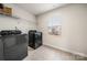 Bright laundry room features washer, dryer, and ample shelving at 717 Windage Way, Pineville, NC 28134