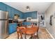 Cozy kitchen features blue cabinets, stainless steel appliances, and a dining area at 844 Turning Point Ln, Concord, NC 28027