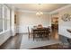 Formal dining room with hardwood floors, wainscoting, large windows, and a view into the kitchen at 8509 Penton Pl, Harrisburg, NC 28075