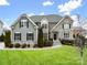 Charming home featuring a manicured lawn, stone accents, and a welcoming entryway with lovely landscaping at 8509 Penton Pl, Harrisburg, NC 28075