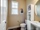 Neat half bathroom with pedestal sink, modern fixtures, and organized storage, offering convenience and style at 8509 Penton Pl, Harrisburg, NC 28075