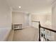 Spacious hallway with decorative chandelier, neutral colors, and a sewing machine in the background at 8509 Penton Pl, Harrisburg, NC 28075