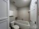 Clean bathroom with a jetted bathtub, tile surround, and white toilet at 9041 J M Keynes Dr # 10, Charlotte, NC 28262