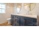 Bathroom with double vanity, stylish mirrors, and white tiled walls at 9489 Westridge Dr, Hickory, NC 28601