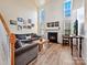 Living room with vaulted ceiling, fireplace, and large windows at 11023 Alderbrook Ln, Charlotte, NC 28270