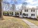 Charming two-story white brick home featuring black shutters, a well-maintained lawn, and manicured shrubbery at 1116 Circlewood Dr, Charlotte, NC 28211