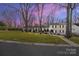 Charming single-Gathering home with traditional architecture, mature trees, and inviting curb appeal at twilight at 1116 Circlewood Dr, Charlotte, NC 28211