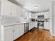 Bright kitchen features white cabinets, stainless steel appliances, subway tile backsplash, and hardwood flooring at 1116 Circlewood Dr, Charlotte, NC 28211