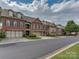 Townhome community with tree-lined street and brick homes at 11756 Easthampton Cir, Charlotte, NC 28277