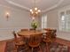 Elegant dining room with round table, chandelier, and hardwood floors at 11756 Easthampton Cir, Charlotte, NC 28277