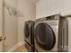 Convenient laundry room with modern washer and dryer, plus extra shelving at 11756 Easthampton Cir, Charlotte, NC 28277