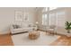 Inviting living room with large windows, hardwood floors, and neutral furniture at 11756 Easthampton Cir, Charlotte, NC 28277