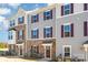 Exterior shot of a townhome featuring stone and gray siding, burgundy shutters, and a manicured lawn at 1419 Newell Towns Ln, Charlotte, NC 28262