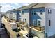 A street view of the exteriors of several townhomes with decks above the garages at 1419 Newell Towns Ln, Charlotte, NC 28262